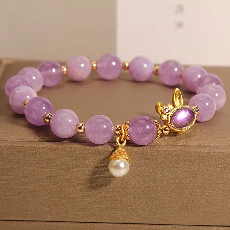 Purplish red mauve jade rabbit head charm on a clear crystal bracelet, Mori style design.