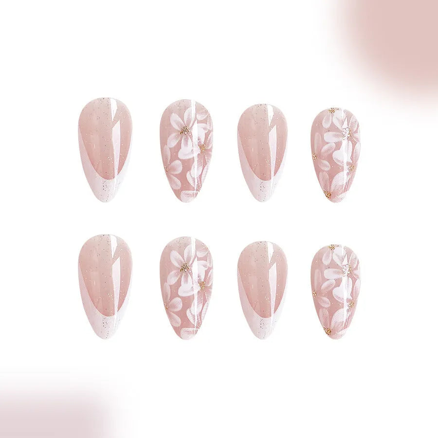 Short almond French style press-on nails with glitter accents and powder flower design on white background