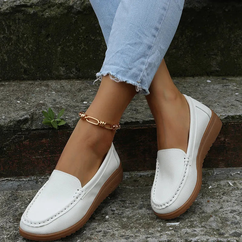 Women's flat PU leather loafers in multiple colours showing round toe and car suture detail.