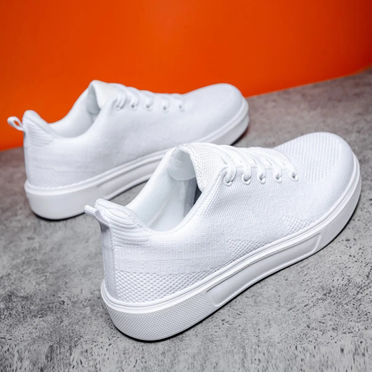 Light white thick sole casual sports shoes with mesh upper and lace-up front.