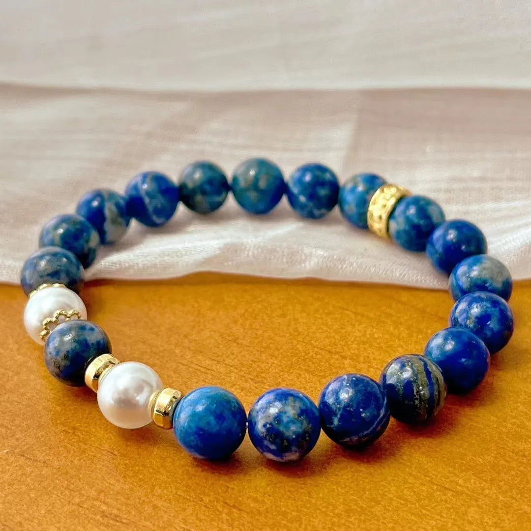Natural green and gold lapis lazuli stone bracelet with a Chinese retro design on a wrist.