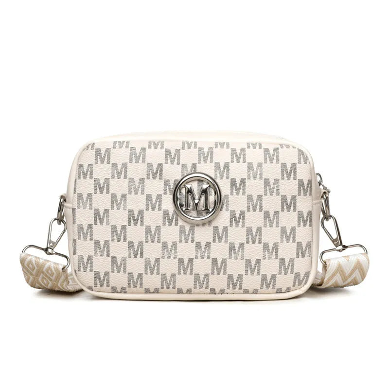 Black crossbody bag with wide strap and a three-dimensional front pocket.