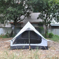 Brown A-line pole-free cabin tent pitched with hiking canes showing spacious interior dimensions