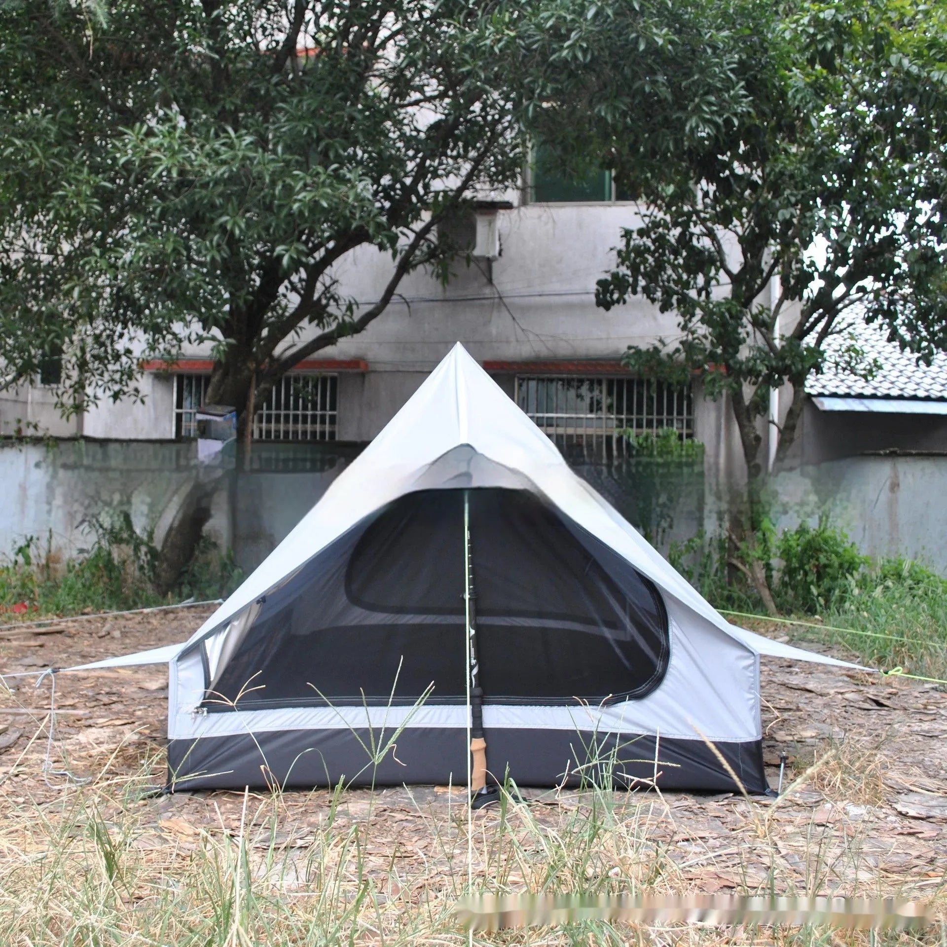 Brown A-line pole-free cabin tent pitched with hiking canes showing spacious interior dimensions