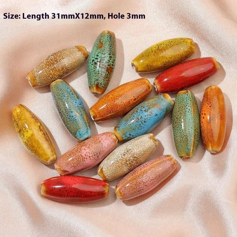 Assorted ceramic bullet beads in pink, yellow, blue, red, coffee, green, and orange colours