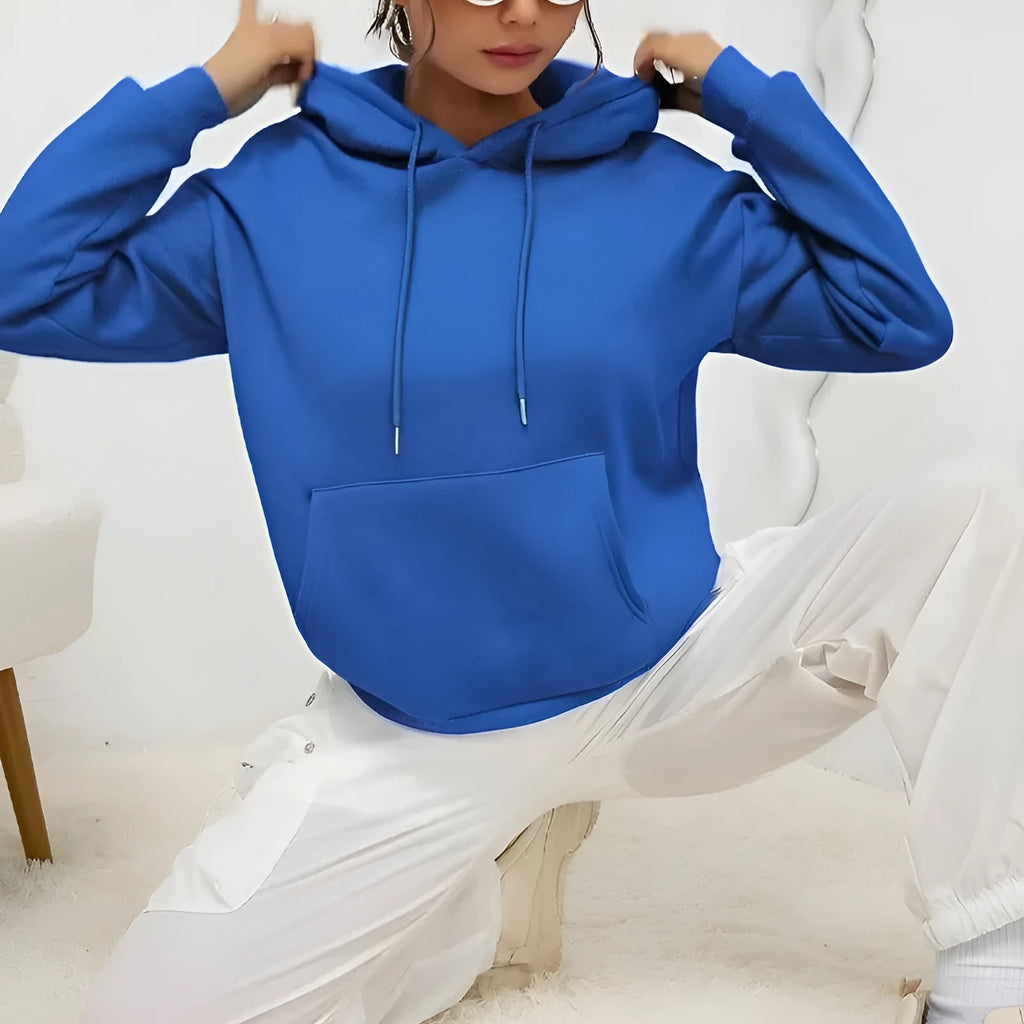 Women's loose grey sweatshirt with a front pocket and drawstring waist, worn with jeans.