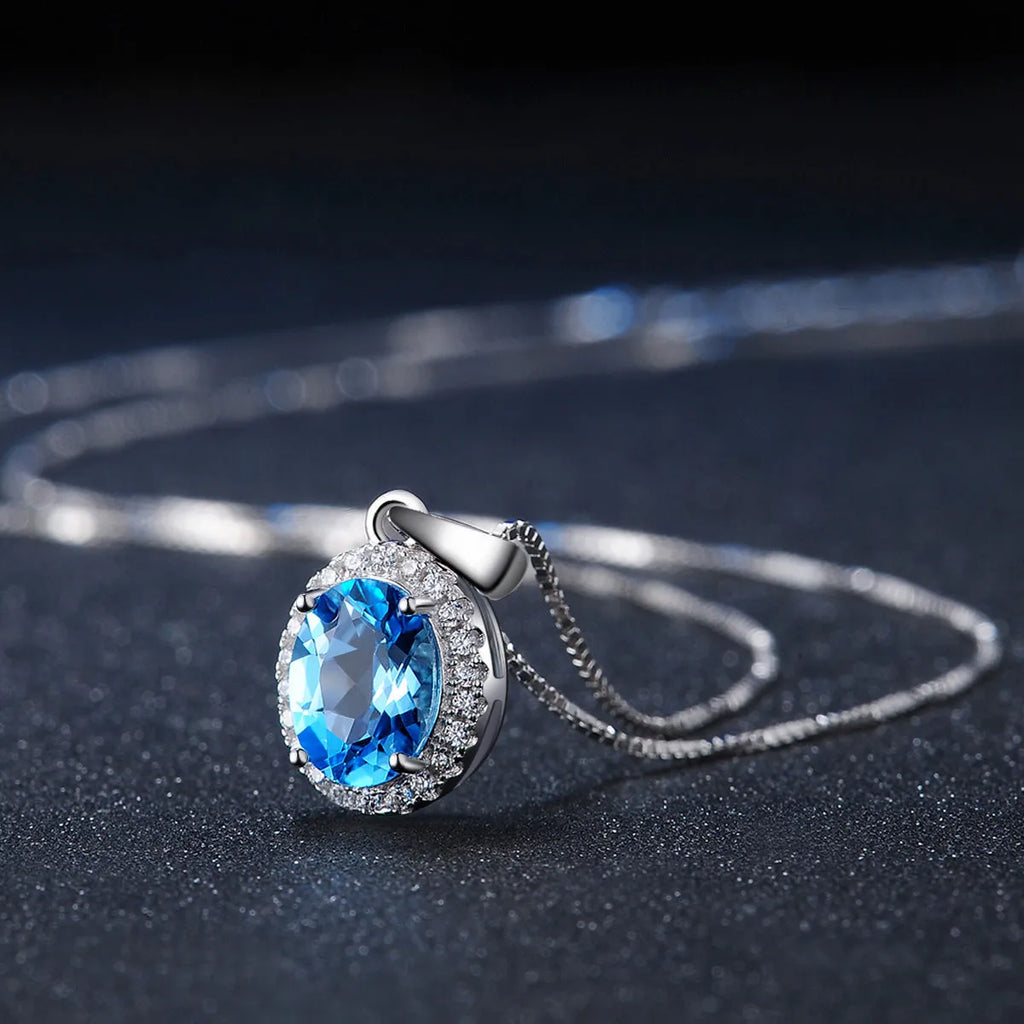 925 sterling silver geometric jewellery set with blue topaz gems showing earrings, ring, necklace, and pendant