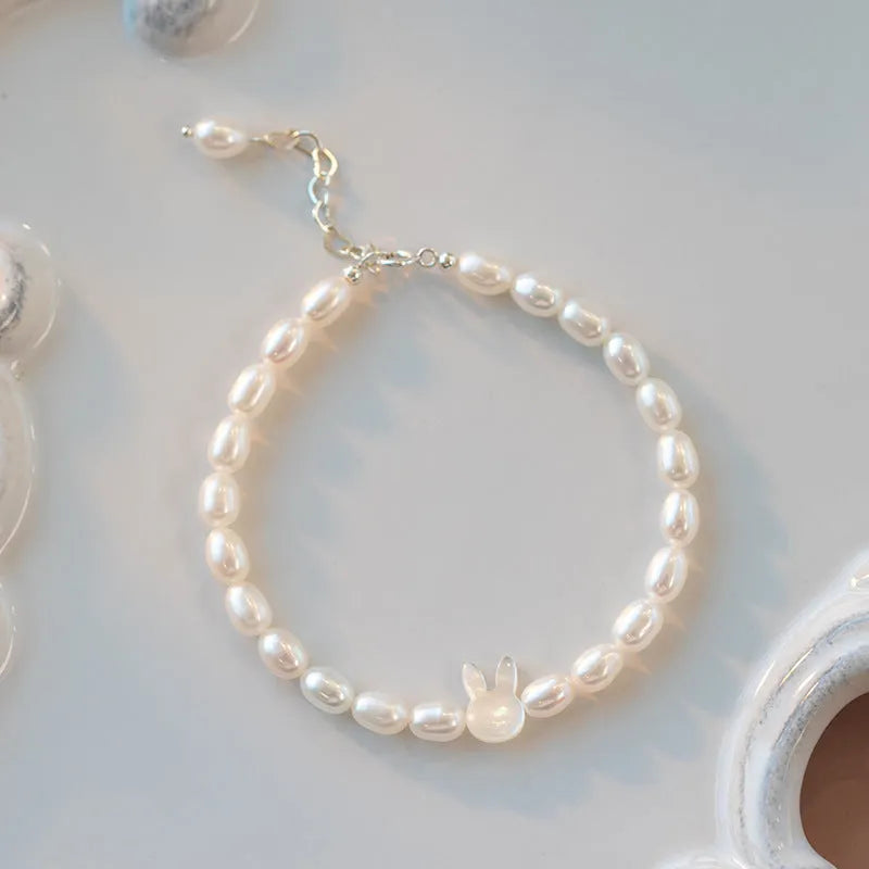 White rabbit bracelet with small pearl beads on an elastic string, silver rabbit charm.