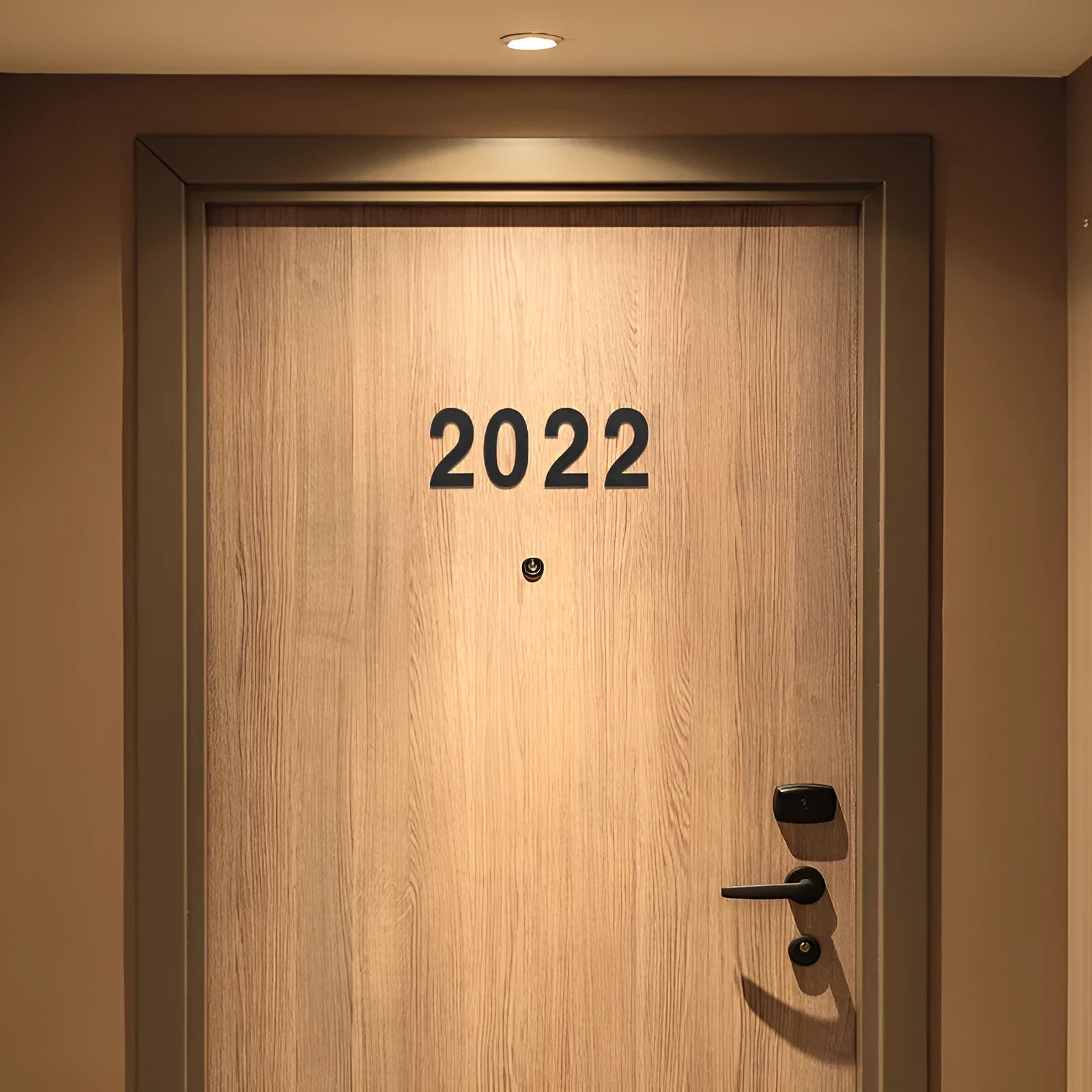Black stainless steel sticky house number sign measuring 7.5cm with self-adhesive backing.