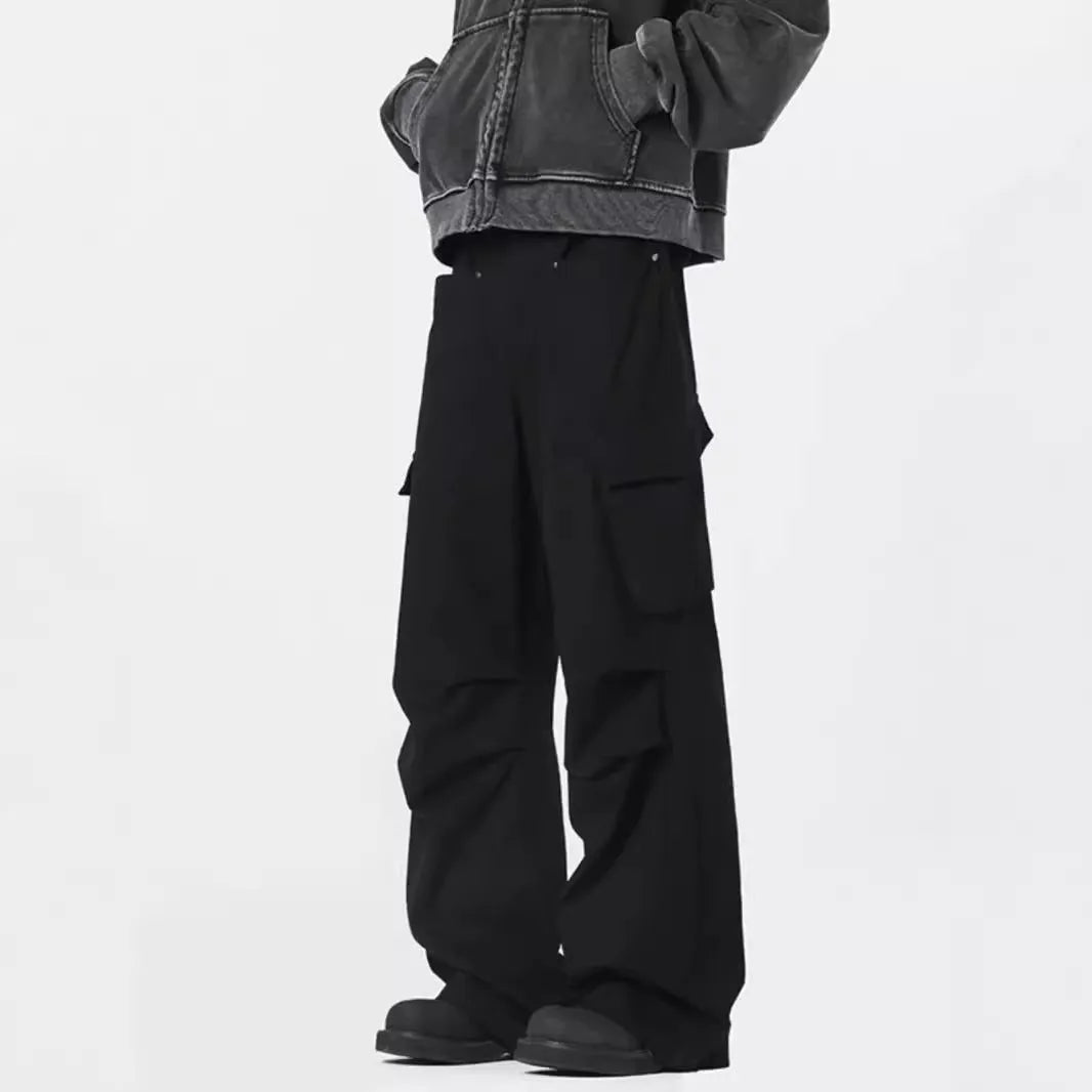 Man wearing black retro high-waist straight-leg casual trousers with a buttoned flap detail.