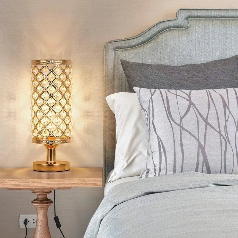 Modern crystal table lamp with hollow-carved design, metal base, gold finish, push button switch, on bedside table