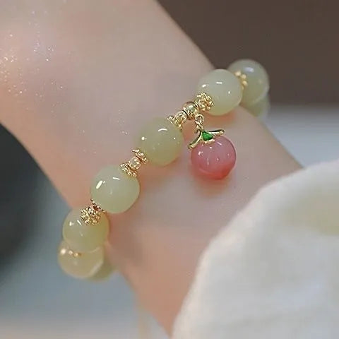 Simple women's bracelet with a peace buckle charm, coloured glass beads, and a small rabbit charm.
