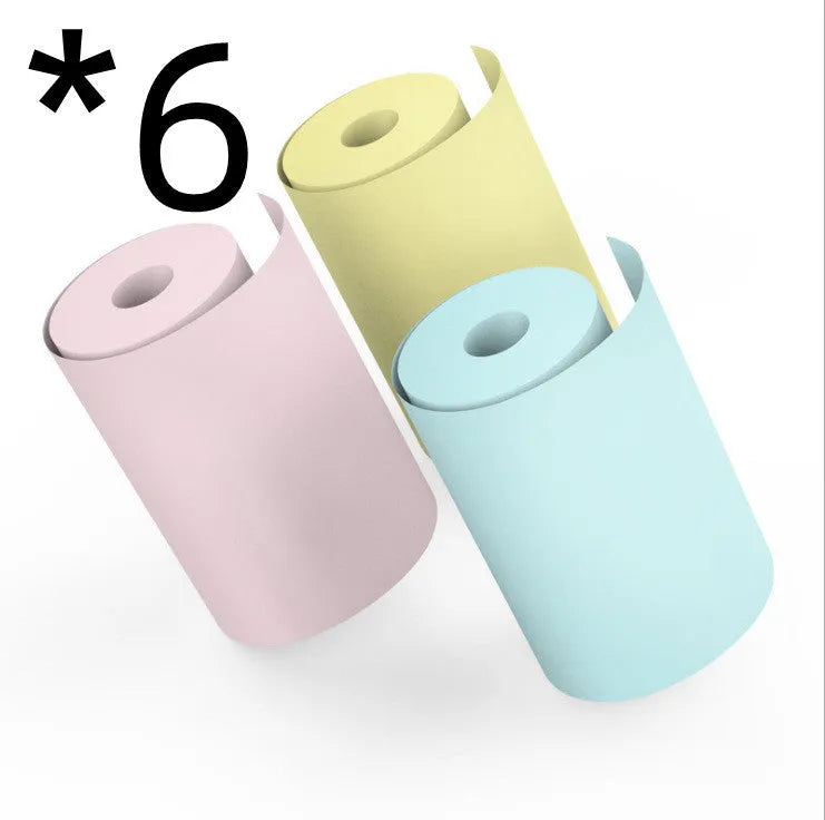 Bluetooth mini thermal photo printer in pink with USB cable and paper rolls on a white background