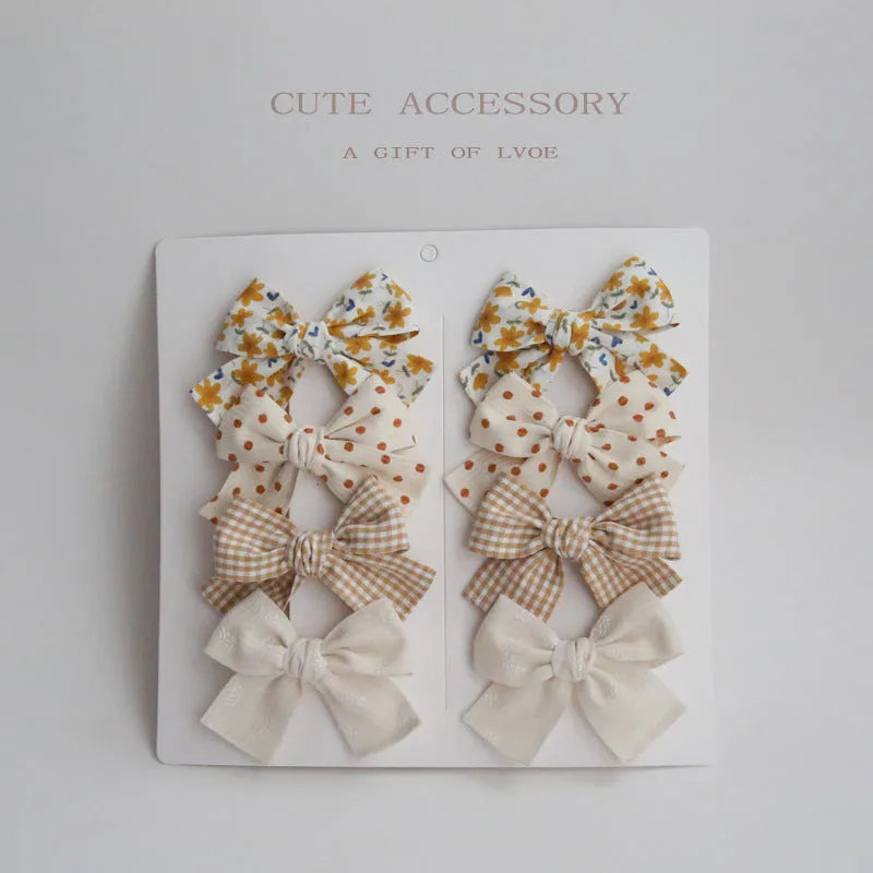 Children's fabric dovetail bow hairclips set showing multiple colour and pattern options