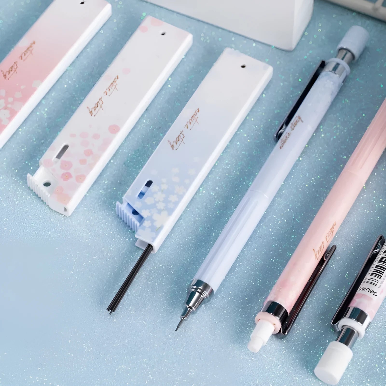 Cartoon design automatic pencil set with three 0.5mm pencils and HB refill boxes on a white background.