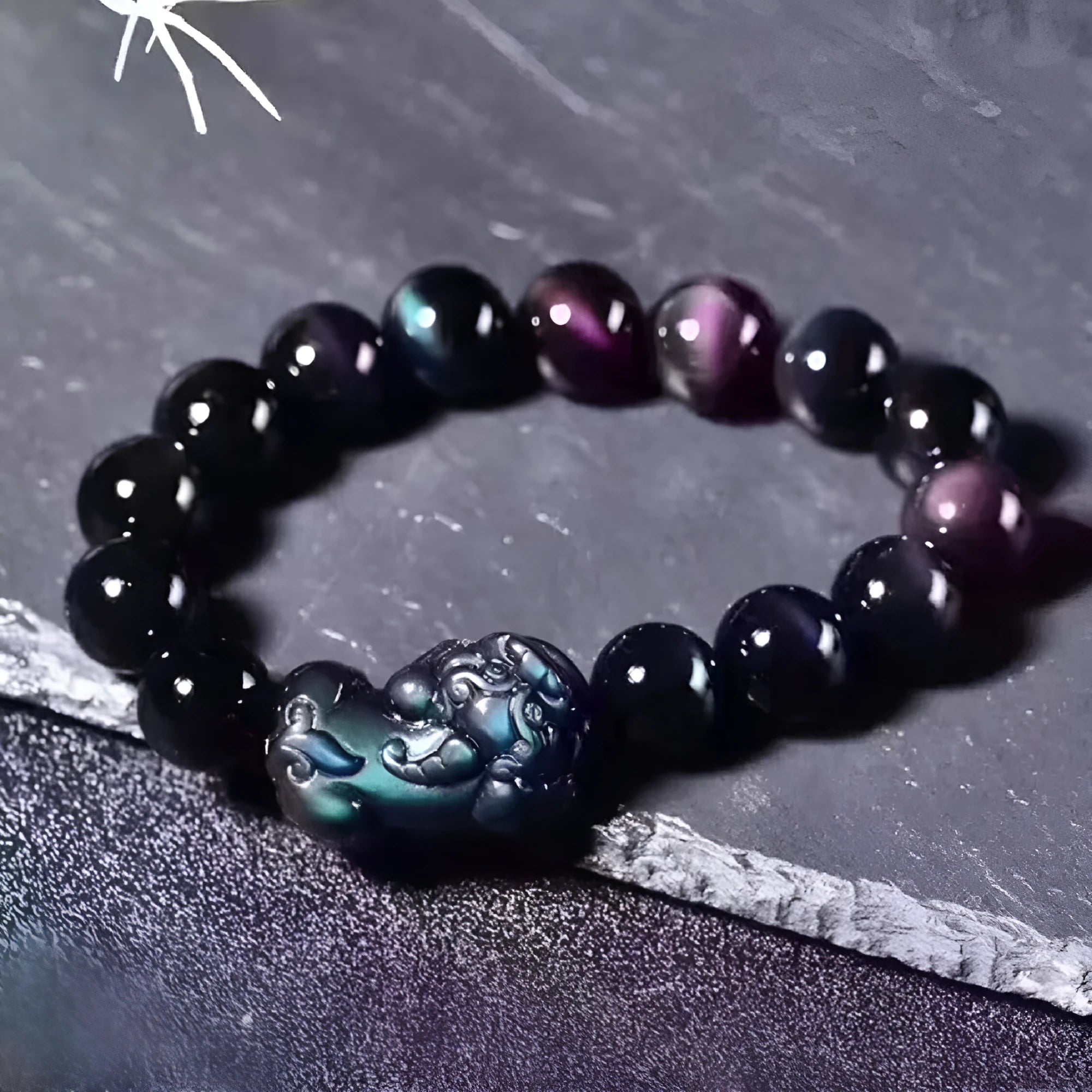 Natural eye obsidian crystal bracelet with ice colour tones and silver clasp on a wrist.