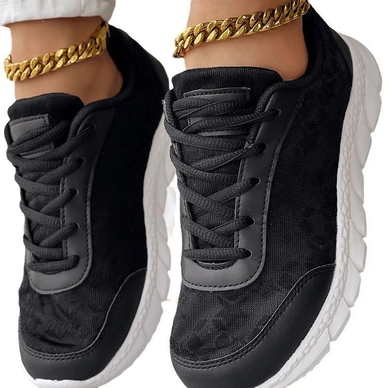 Women's white canvas running shoes with flat heel and round toe on a light background.