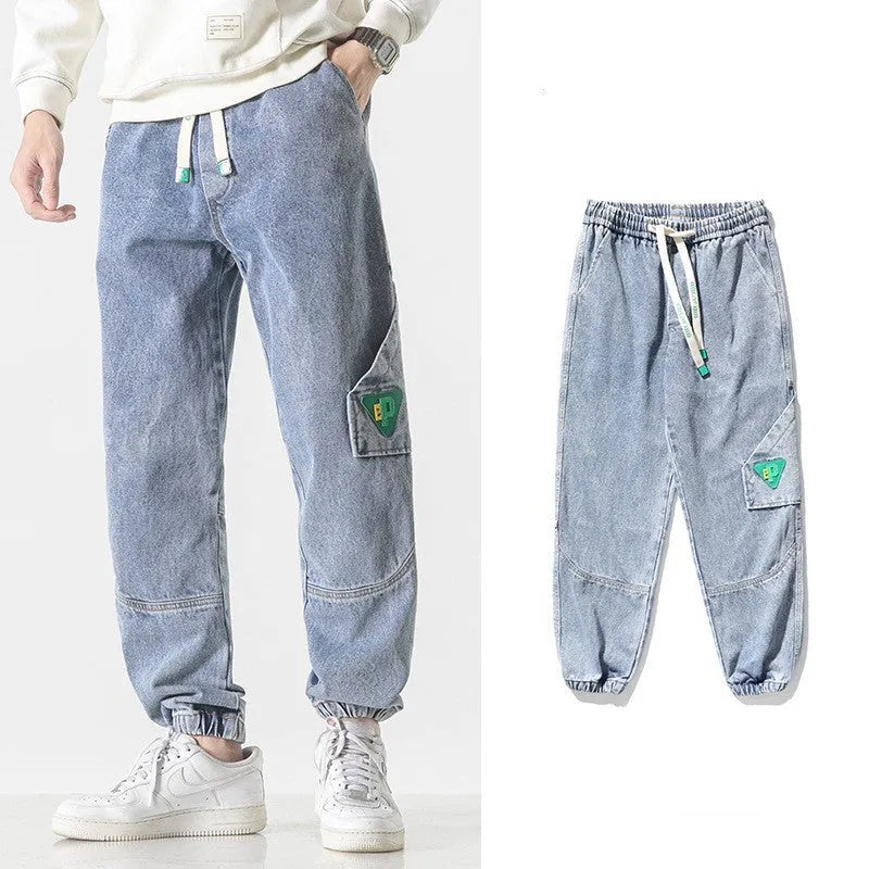 Men's loose-fit tapered cotton trousers in black, shown on a hanger