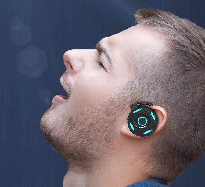 Black and white Bluetooth gaming earphones with hanging ear design and USB charging cable