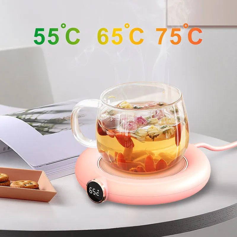 White USB cup warmer pad with LED display on a desk next to a mug.