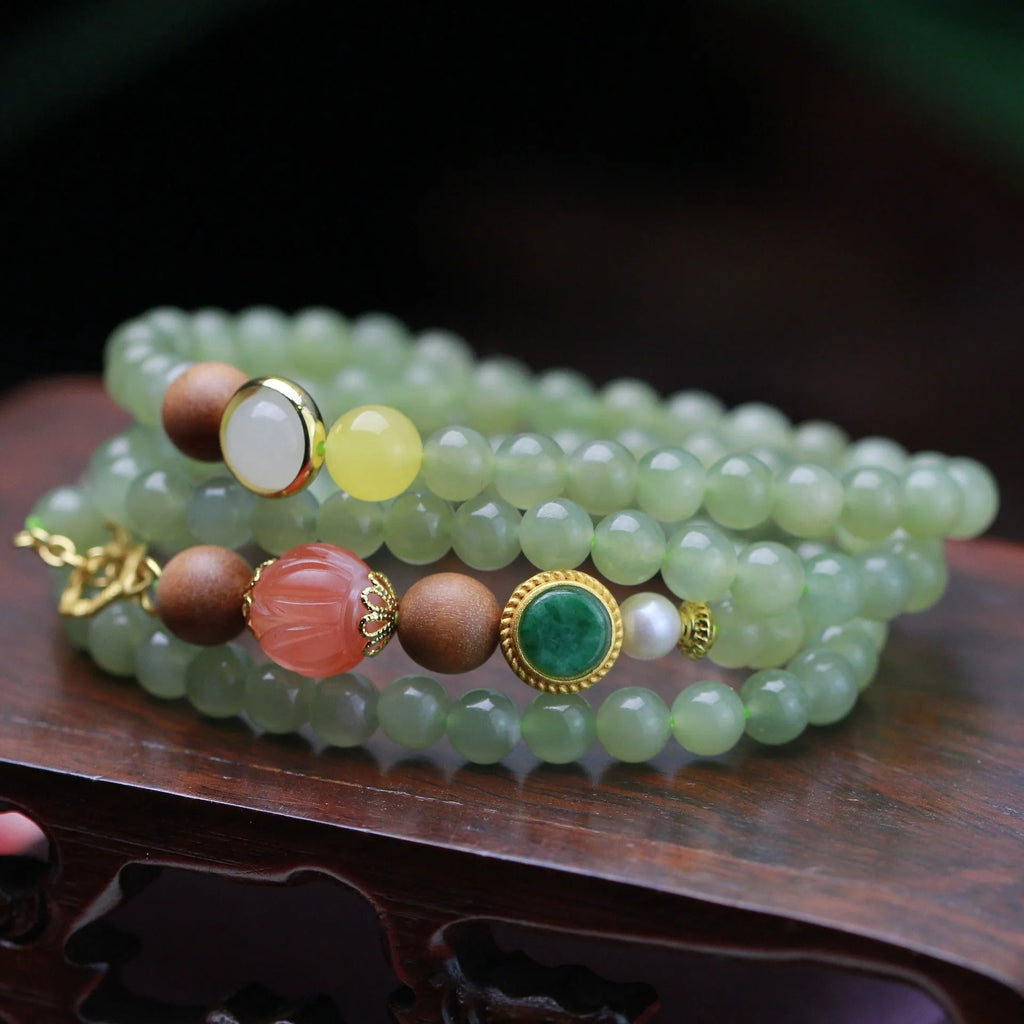Hetian jade necklace with red lotus beads, white sandalwood, and beeswax, featuring a fu charm and zodiac animal design.