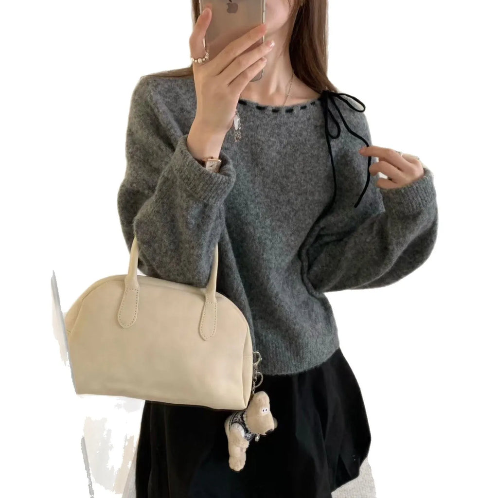 Grey loose-fit women's knit pullover top on a hanger.