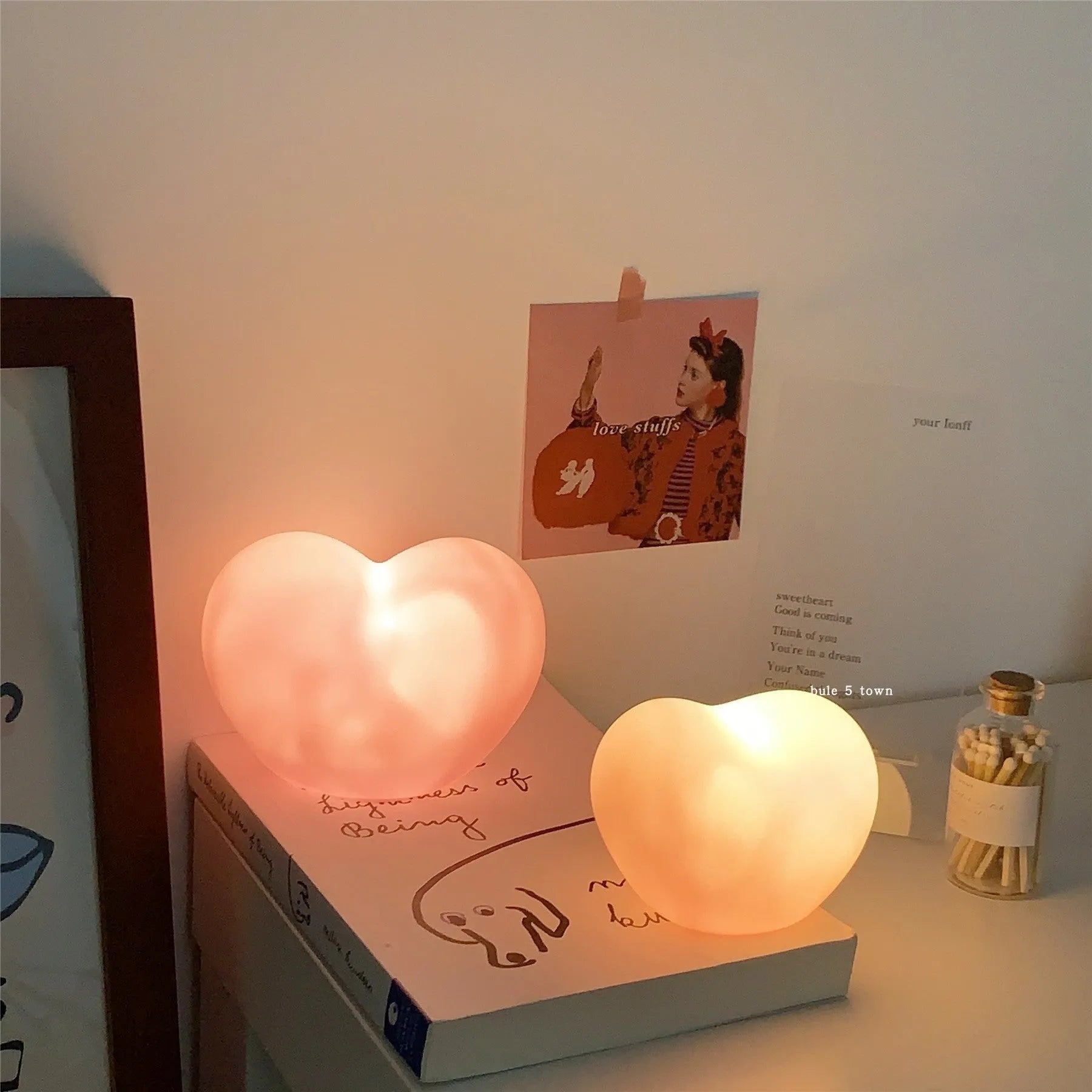 Pink and white vinyl trumpet-shaped atmosphere lamps in two sizes on a table