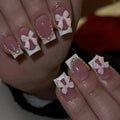 Short artificial French manicure nails with white bow, tulip, and starry sky designs on a square tip.
