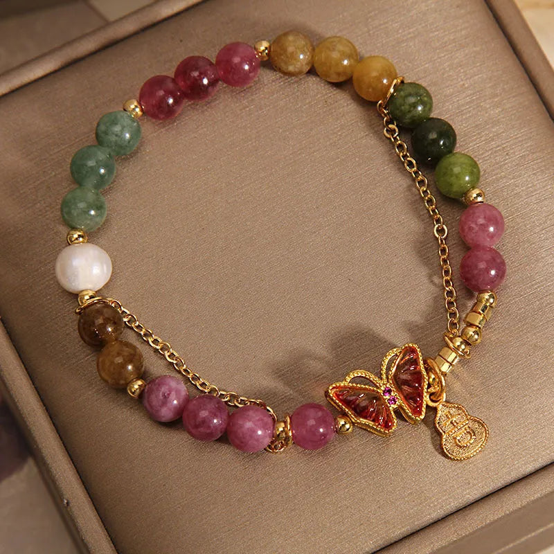 Women's agate and tourmaline bracelet with a detailed butterfly-shaped gourd charm in natural jade colours.
