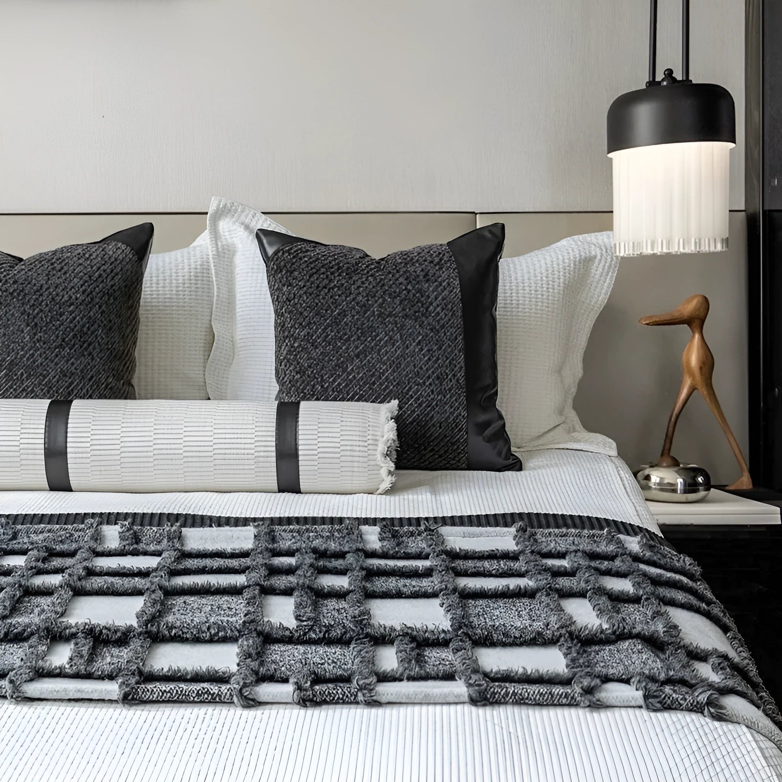 Modern grey and white plaid bed runner blanket set with a matching pillowcase and round pillow on a double bed.