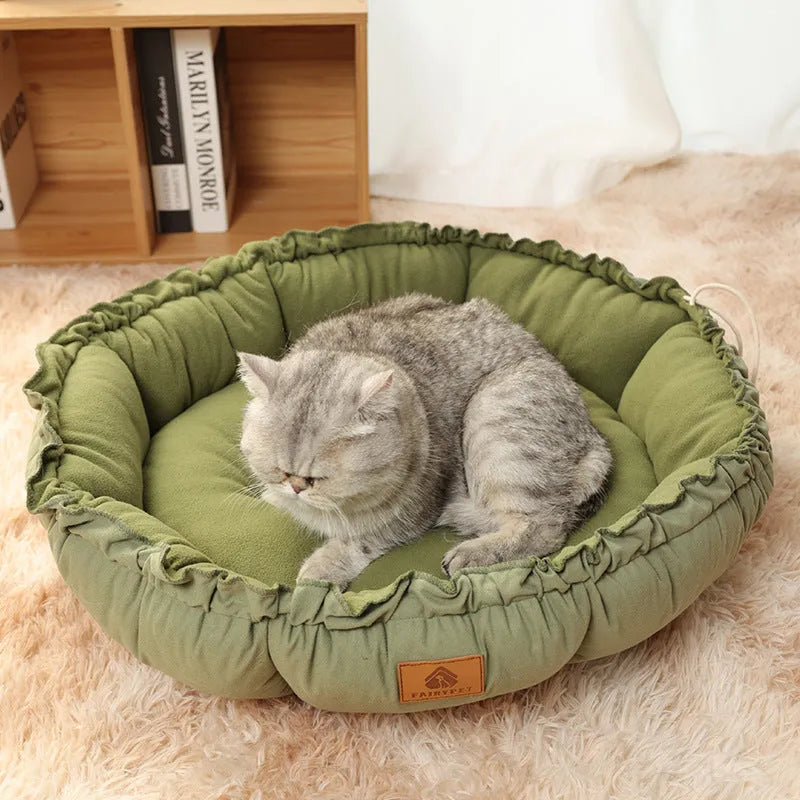 Grey reversible donut-shaped cat bed with raised rim, shown next to a green version of the same bed.
