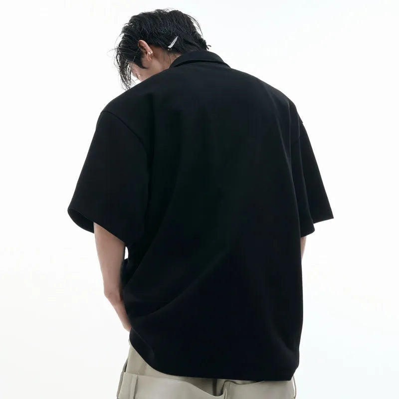 Men's black geometric print polo shirt with deconstructed collar and short sleeves, loose fit.
