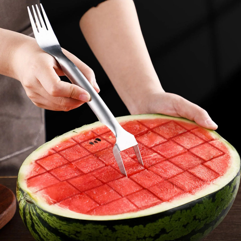 Silver stainless steel watermelon slicer and serving fork on a kitchen counter