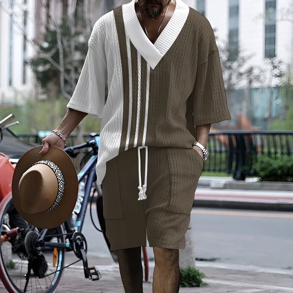 A man wearing a printed drop-shoulder knitted top and matching shorts from a casual two-piece loungewear set.