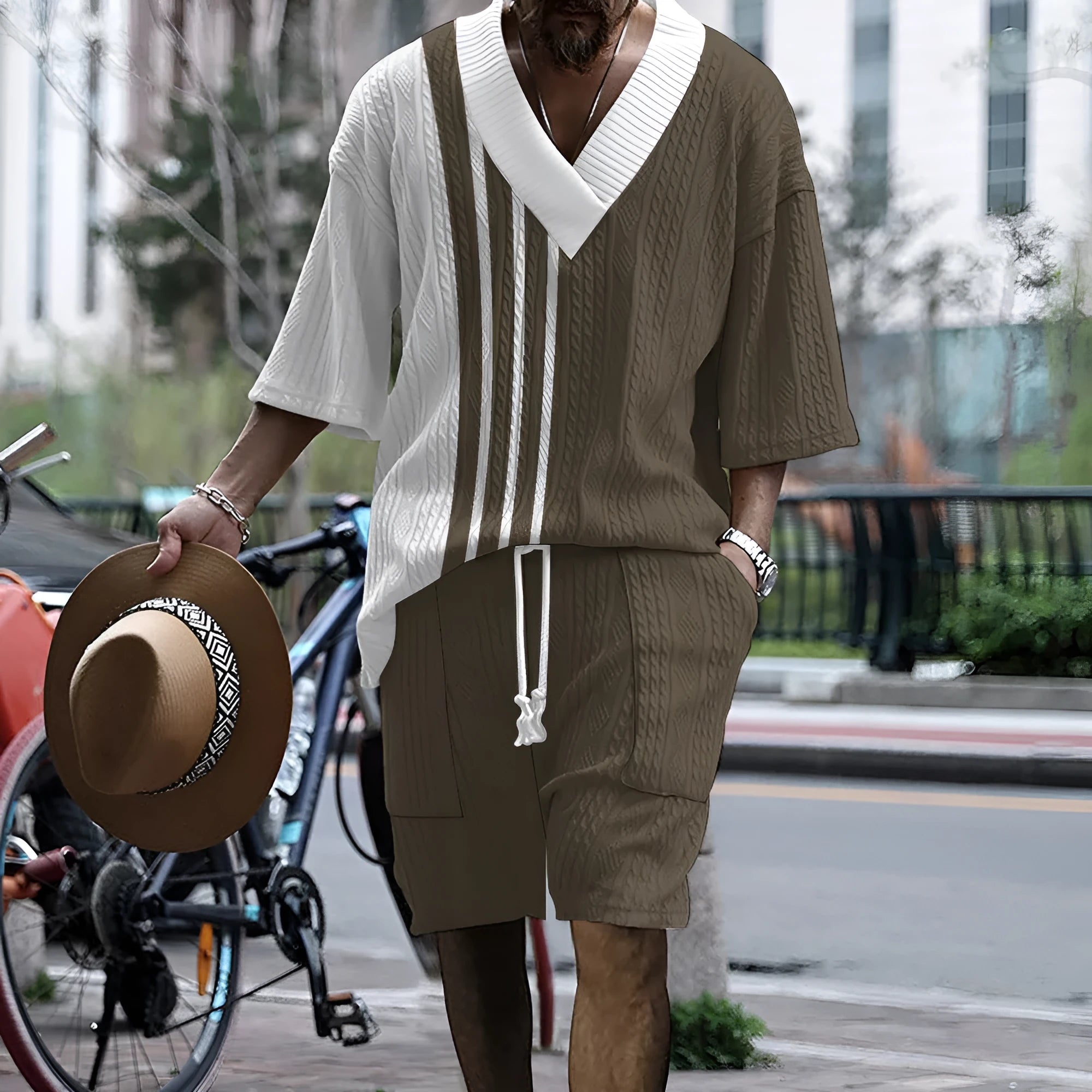 A man wearing a printed drop-shoulder knitted top and matching shorts from a casual two-piece loungewear set.