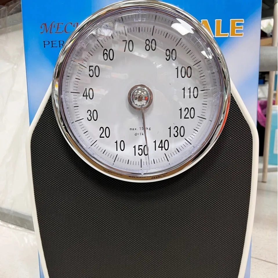Black mechanical body weight scale with large analogue dial on a simple platform.