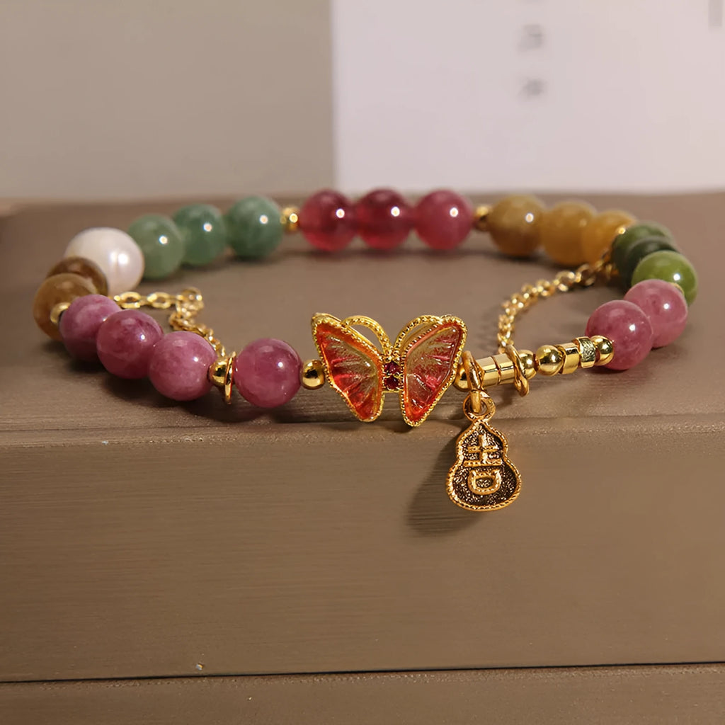 Women's agate and tourmaline bracelet with a detailed butterfly-shaped gourd charm in natural jade colours.