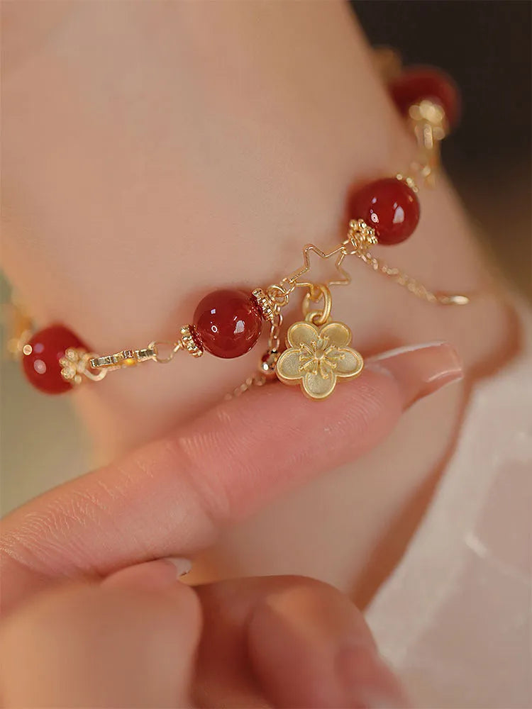 Red agate double layer bracelet with floral and peach blossom detailing on woman's wrist