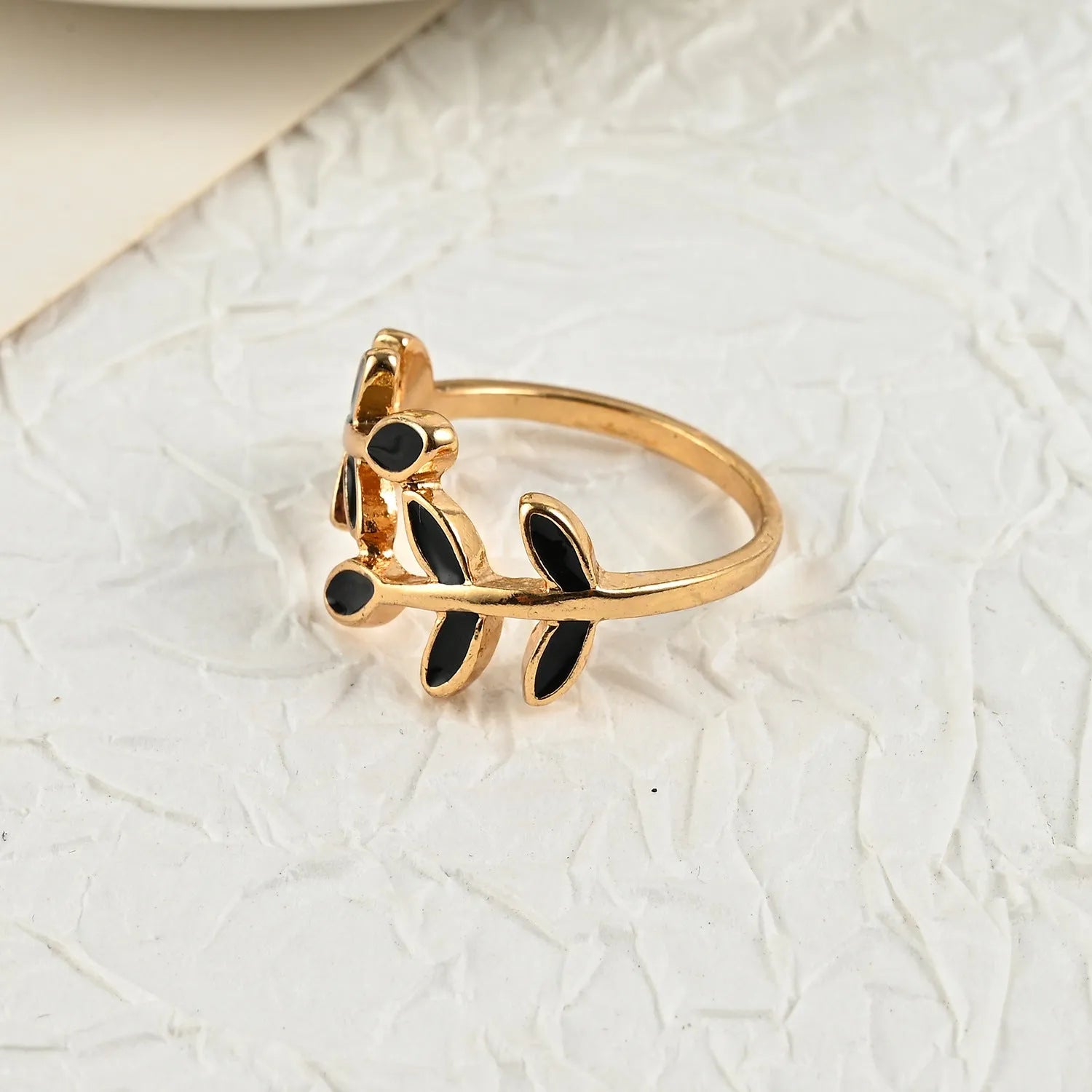 Gold geometric leaf design acrylic ring for women on a white background.