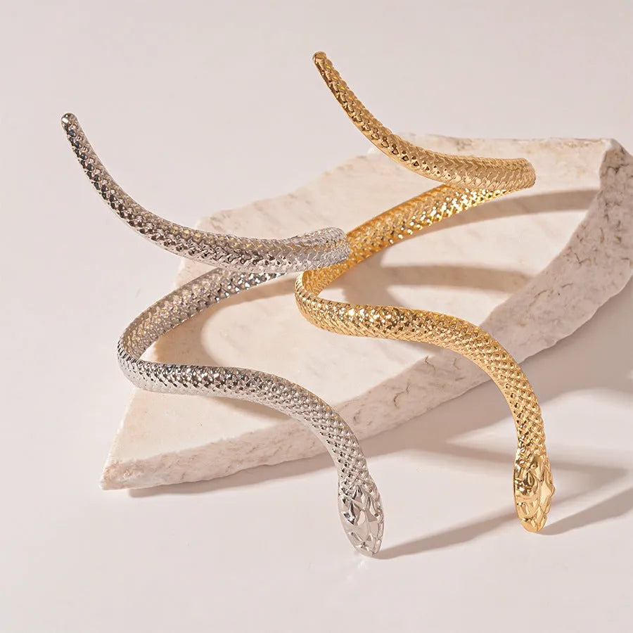 Gold and silver snake-inspired ring and bracelet set with twisted winding design