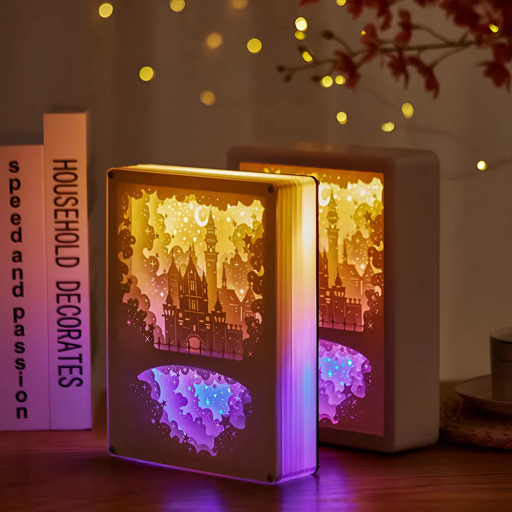 Modern three-dimensional paper carving night light with USB cable and remote control on a bedside table.