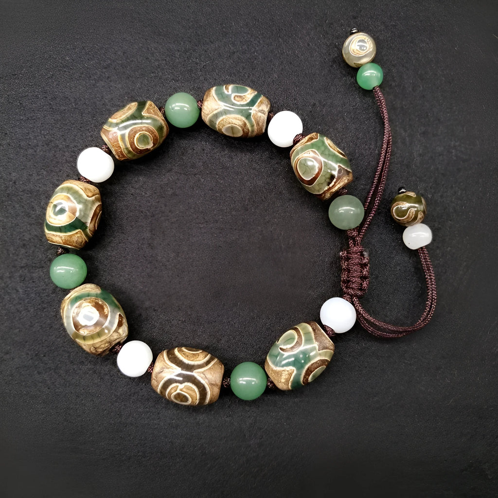 Green agate hand-woven Tibetan bracelet with three-eye geometric design on a wrist.