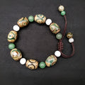 Green agate hand-woven Tibetan bracelet with three-eye geometric design on a wrist.