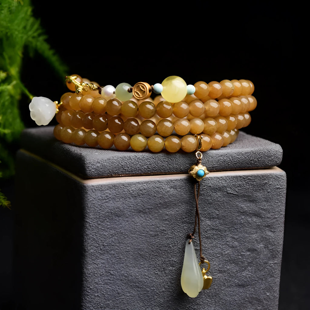 Close-up of a women's green jade bracelet with 6mm beads, beeswax, and leaf charms on a wrist.
