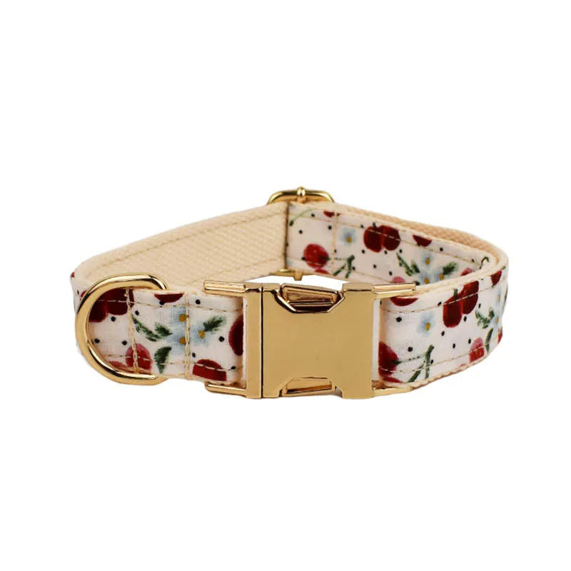 Red cherry print dog collar set with matching leash, vest, and light gold buckle