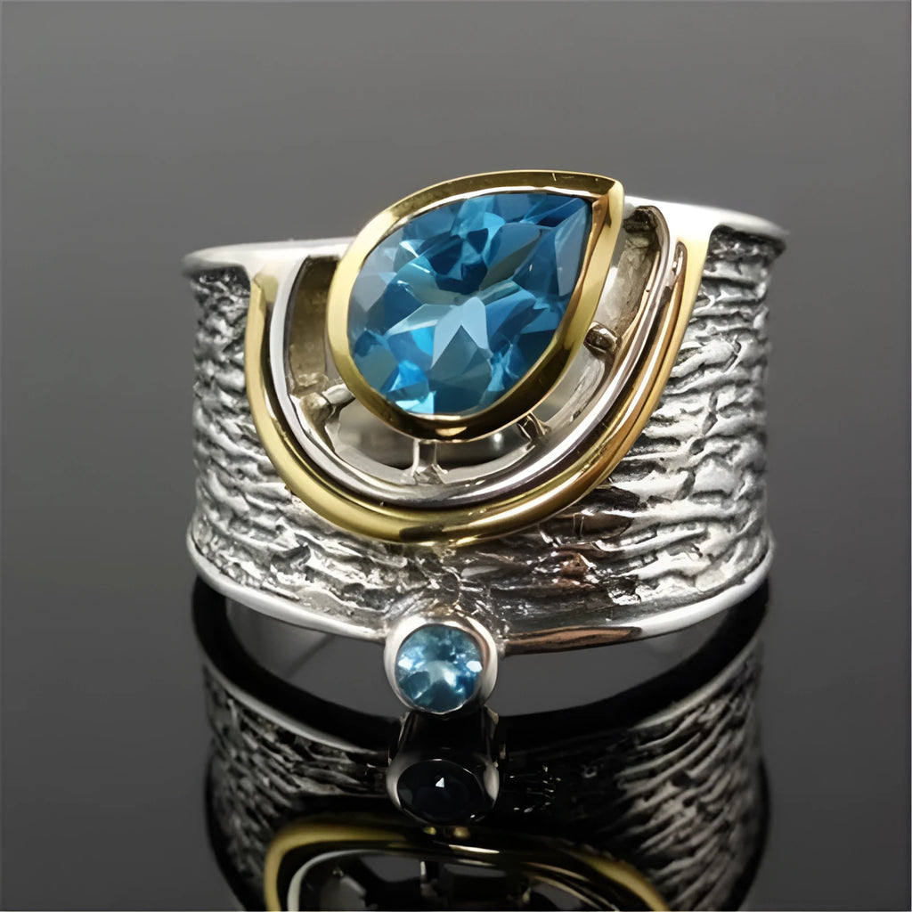 Women's blue zircon drop shape alloy ring with Chinese style design on a white background.