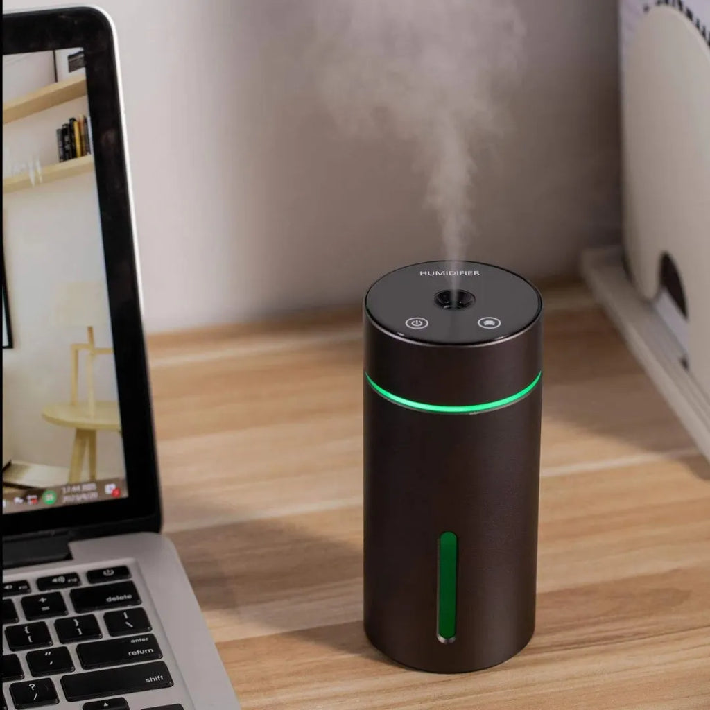 Black aluminium portable car humidifier and essential oil diffuser with night light on a desk