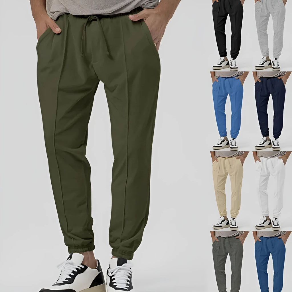 Men's grey loose tapered track sweatpants on a hanger, showing straight-leg design.
