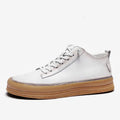 A pair of black men's round-toe casual leather shoes with white laces on a flat rubber sole.