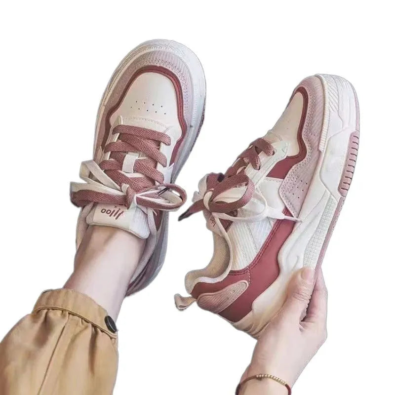 Pink and white low-top spring sneakers with rubber sole on a plain background